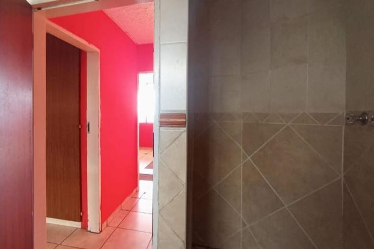 A view of a bathroom interior featuring tiled walls and flooring, showing potential for modernization and cosmetic updates.