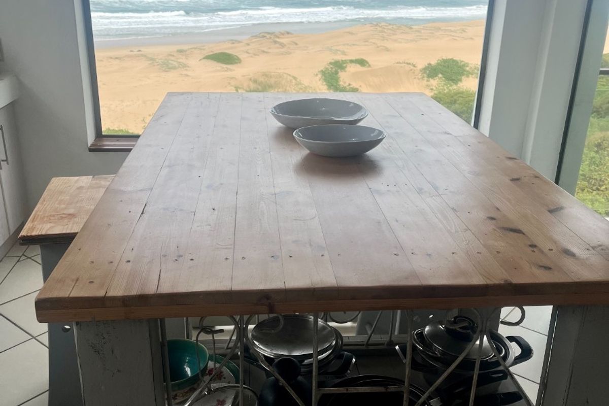 Kitchen area featuring tiled flooring and a large picture window offering expansive ocean and beach views.