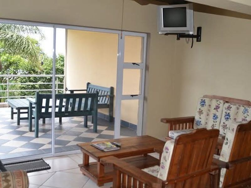 Open plan living area featuring tiled floors and large sliding glass doors leading to an outdoor patio area.