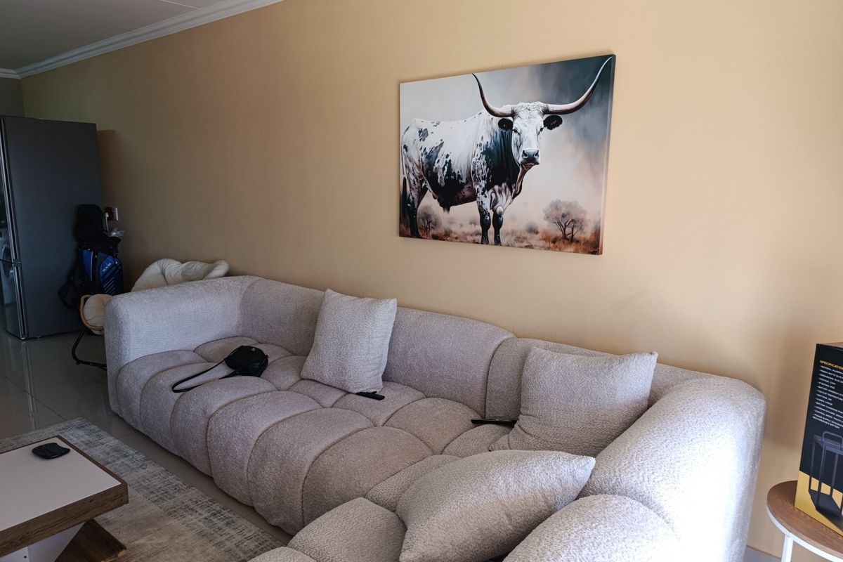 A living room area featuring neutral wall paint, coving, and tiled flooring, providing a functional space for relaxation.