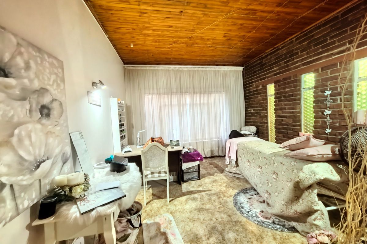 A bedroom featuring a warm timber ceiling and a rustic exposed brick wall, currently utilized as a beauty treatment space.