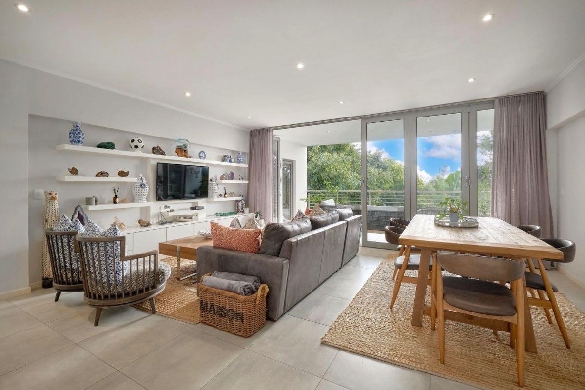 Spacious open-plan living and dining area featuring large sliding glass doors that provide abundant natural light and seamless access to the balcony.