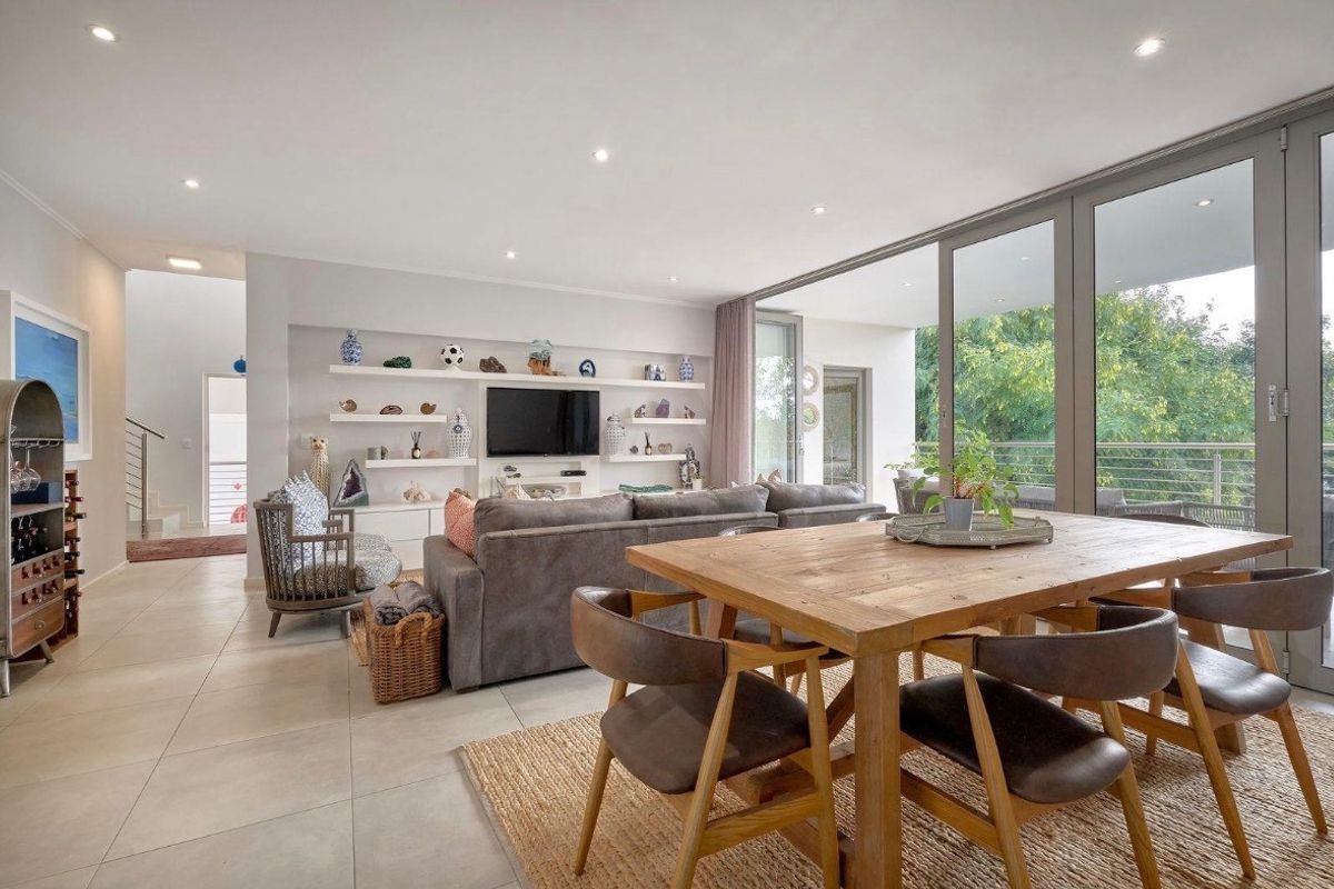 Spacious open-plan living and dining area featuring large sliding glass doors that provide abundant natural light and seamless access to the outdoor balcony.