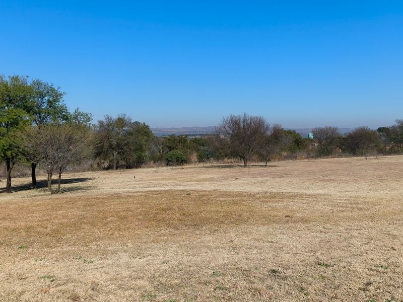 A wide-angle view of the expansive, open landscape and natural vegetation on the small holding property.