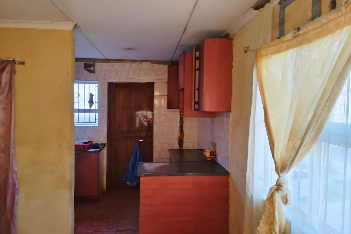 A dated kitchen area featuring built-in cabinetry and tiled splashbacks, currently requiring significant renovation and cosmetic updates to improve functionality and aesthetic appeal.