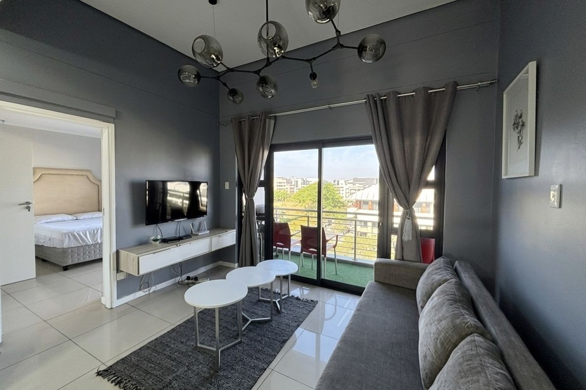 Modern living room featuring tiled floors, a floating media console, and large sliding glass doors leading to a private balcony.