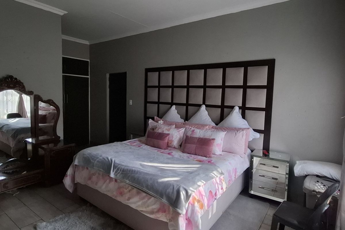Spacious bedroom featuring tiled flooring, a built-in cupboard, and a decorative coved ceiling, offering a comfortable and functional living space.
