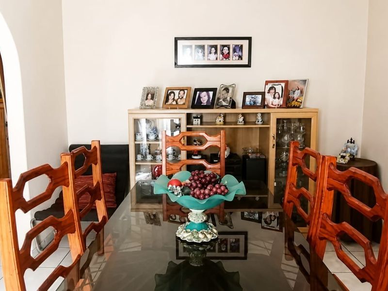 A dining room featuring tiled flooring and an arched doorway leading to an adjacent space.