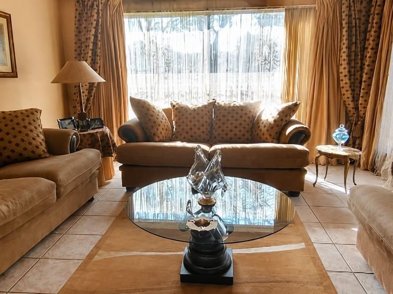 A comfortable living room featuring tiled flooring and a large window that allows for natural light.
