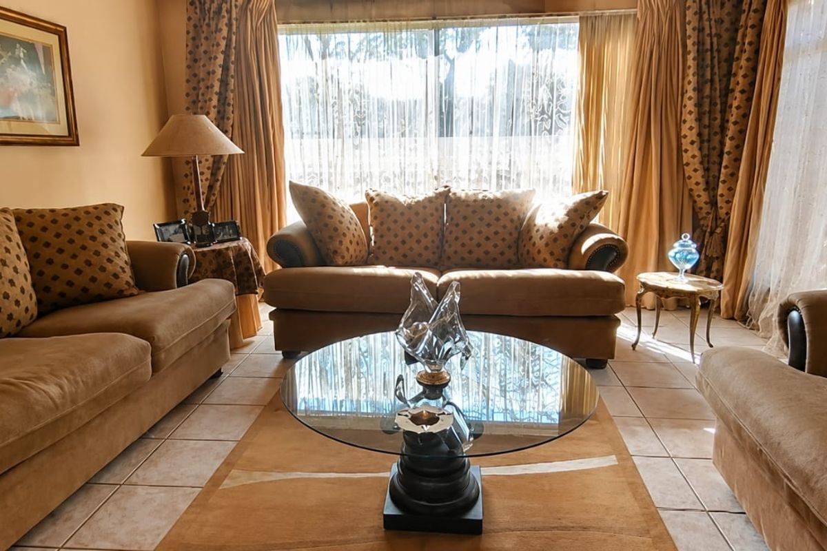 A comfortable living room featuring tiled flooring and a large window that allows for natural light.