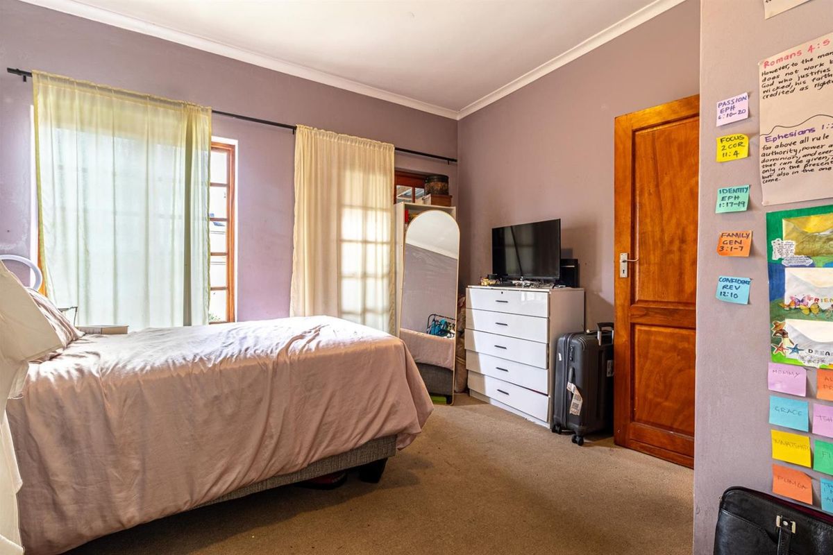 A standard bedroom featuring carpet flooring, timber door, and timber window frames with natural light.