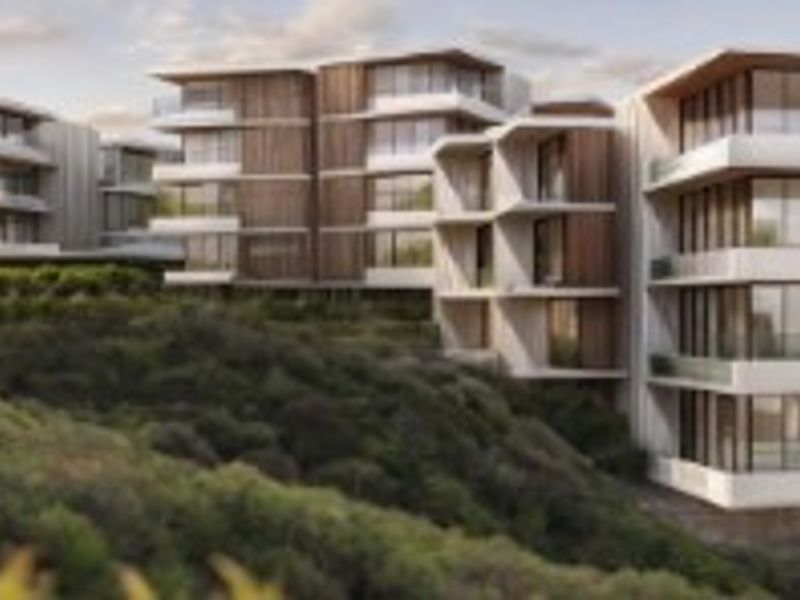 An aerial perspective of a modern multi-story residential development featuring timber-clad facades and expansive balconies set within a landscaped hillside environment.