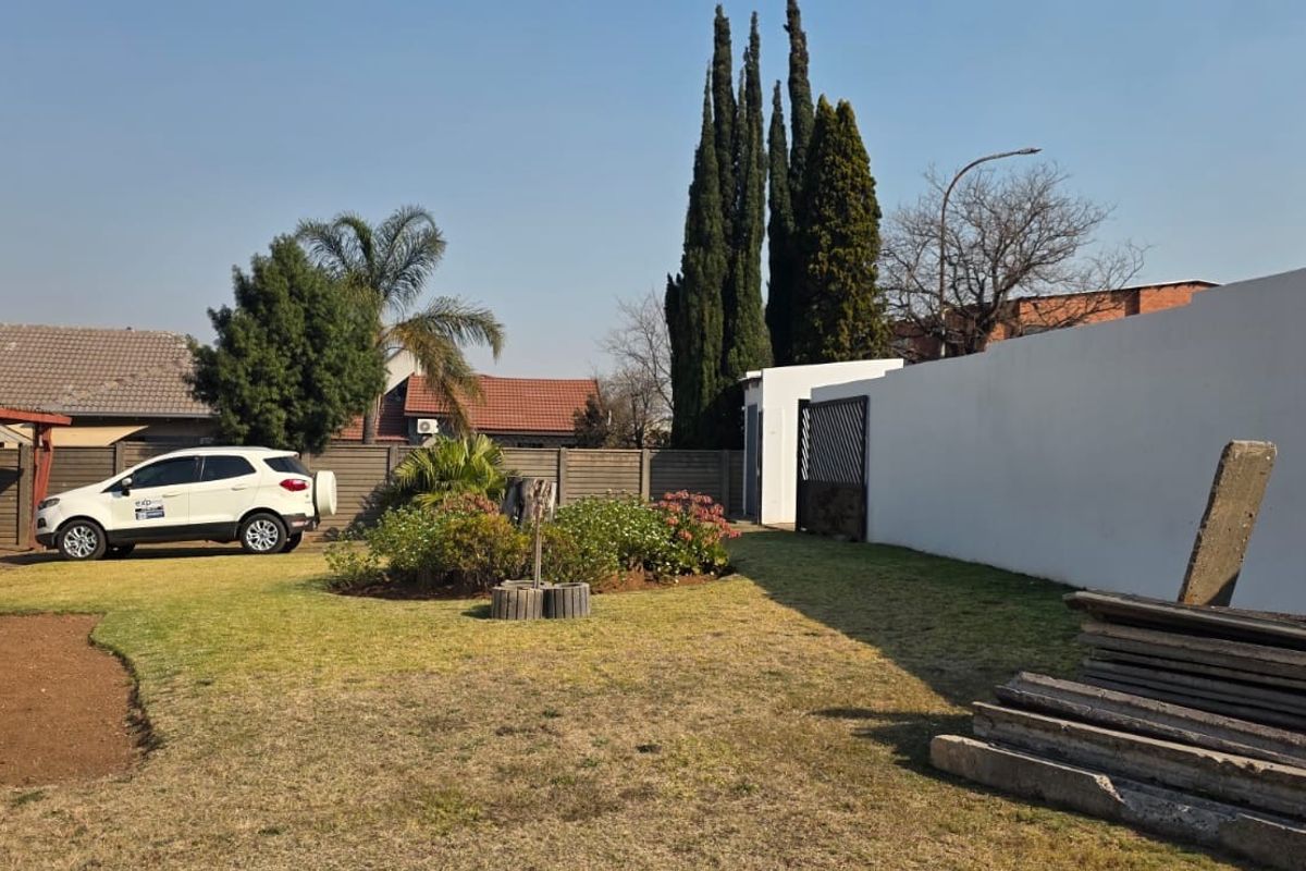 A view of the rear garden area featuring a boundary wall and lawn space.