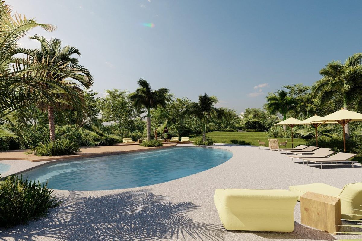 A beautifully landscaped outdoor pool area featuring a curved swimming pool surrounded by lush greenery and a spacious paved deck.