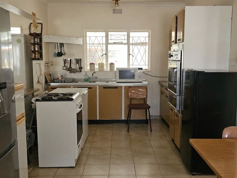 A functional kitchen featuring dated cabinetry, tiled flooring, and built-in oven, offering potential for modernization and aesthetic updates.