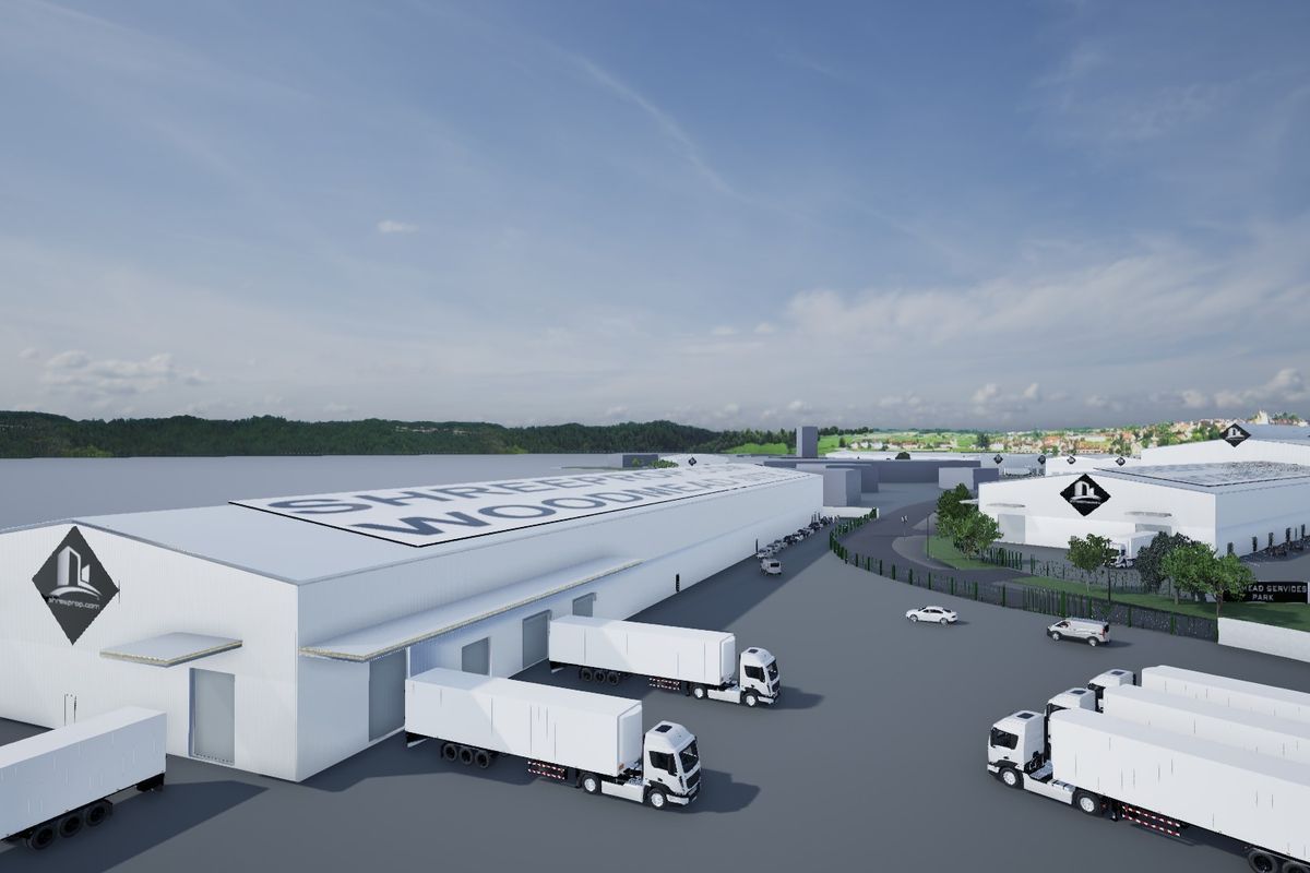 Aerial view of a large industrial warehouse complex featuring extensive loading docks, paved yard space, and secure perimeter fencing.