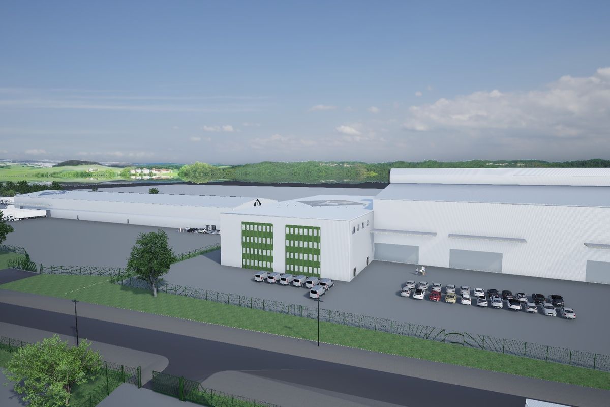 Aerial view of a large industrial warehouse facility featuring extensive parking, loading bays, and secure perimeter fencing.
