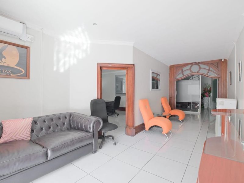 A commercial office reception area featuring tiled flooring, decorative wooden archways, and an integrated air conditioning unit.