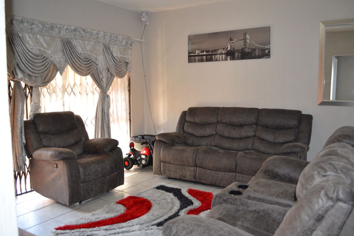 A living room featuring tiled flooring and a security gate, providing a functional and secure living space.