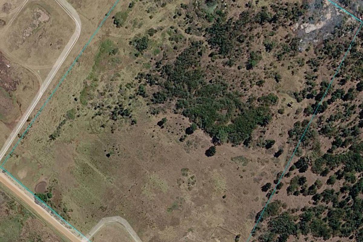 Aerial view of the small holding property showing the land boundary, access road, and existing structures on the plot.