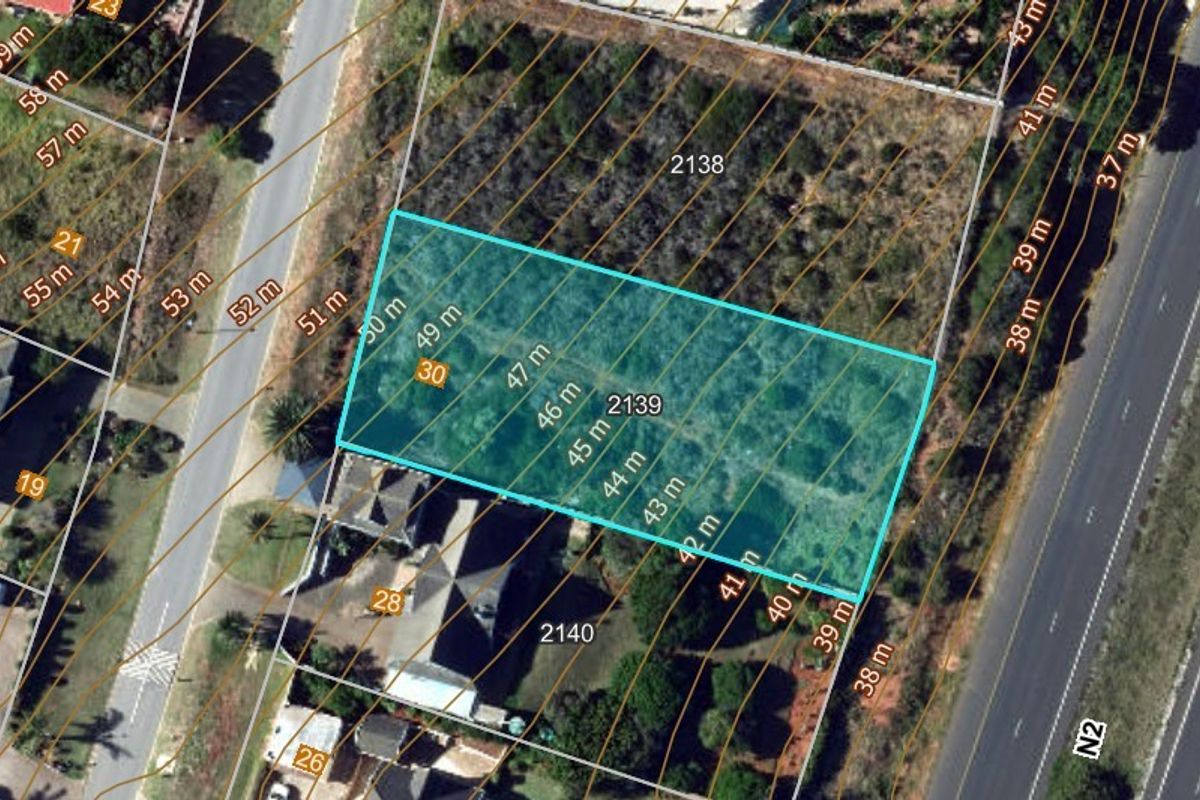Aerial view of a vacant residential plot featuring topographical contour lines and clearly marked property boundaries.