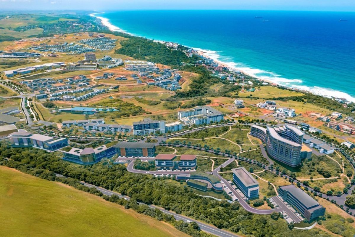Aerial view of a coastal commercial development site featuring established road infrastructure and surrounding natural landscape.