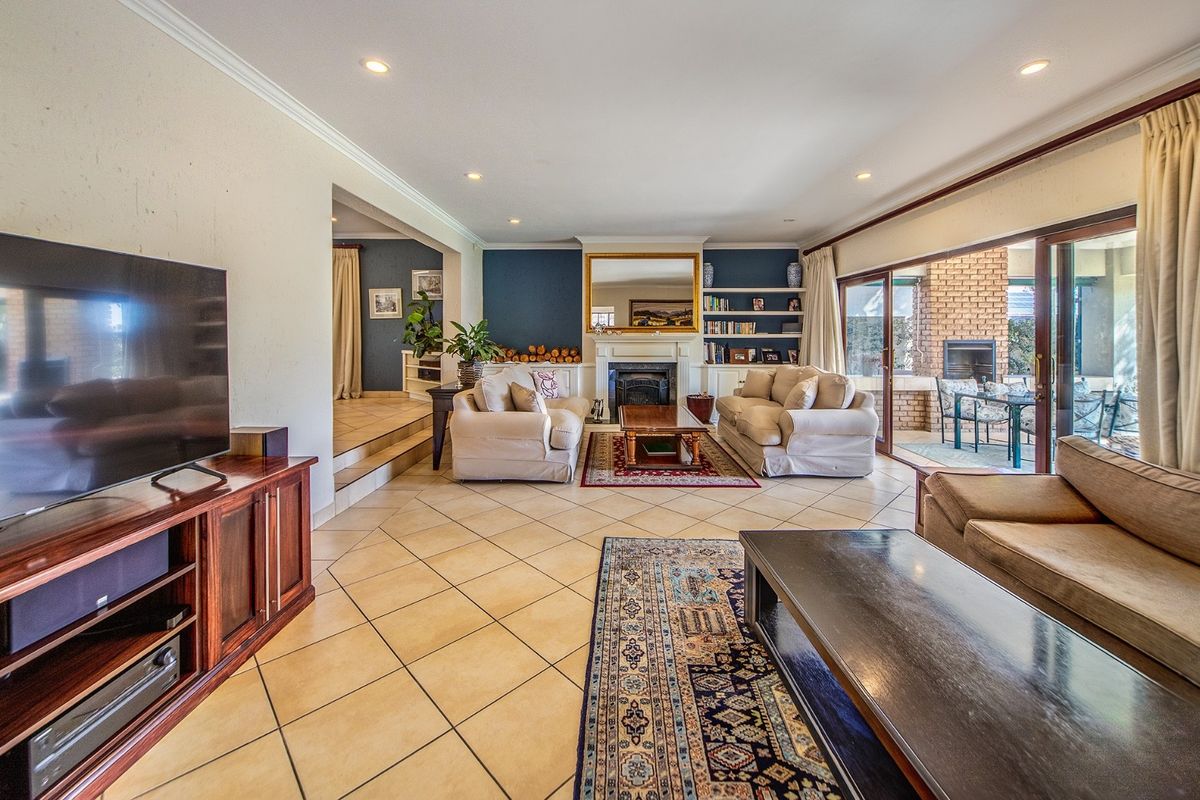 Spacious living room featuring a fireplace, built-in shelving, and large sliding glass doors that provide seamless access to the outdoor patio area.