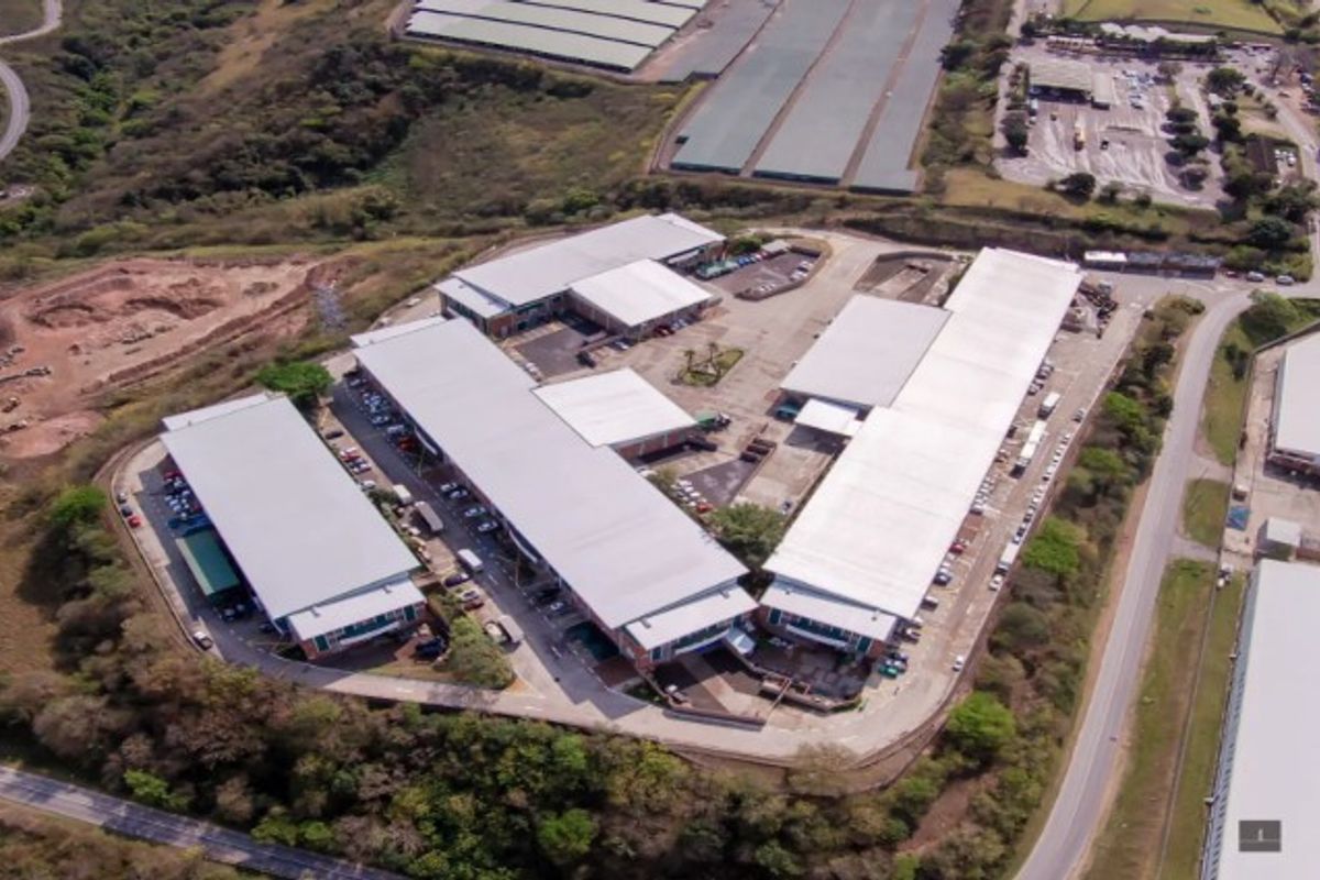 Aerial view of an industrial warehouse complex featuring multiple large-scale buildings, metal roofing, and paved access roads within a secure perimeter.