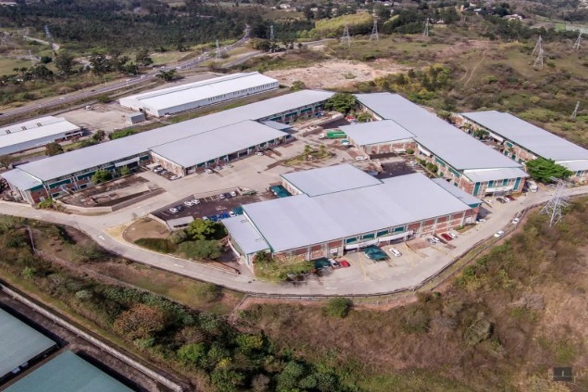Aerial view of a large industrial park featuring multiple warehouse buildings with metal roofing, paved parking, and surrounding access roads.