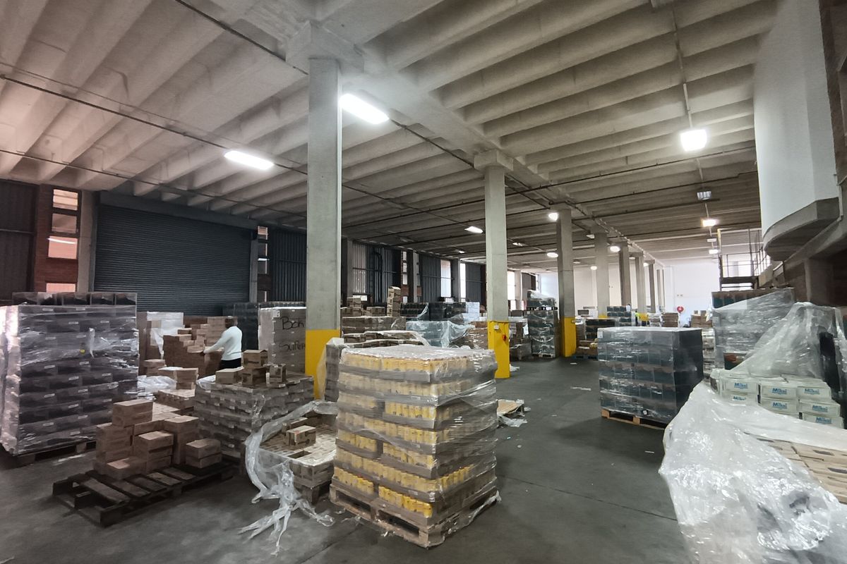 Spacious industrial warehouse area featuring high concrete ceilings, structural columns, and durable concrete flooring, suitable for storage or logistics operations.