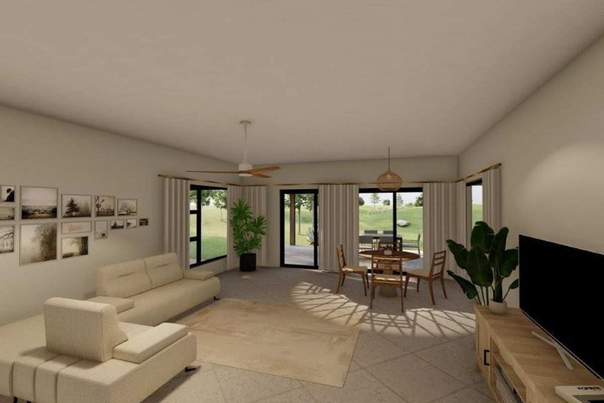 A bright and spacious living room featuring tiled flooring, a ceiling fan, and large sliding glass doors that provide access to the outdoor area.