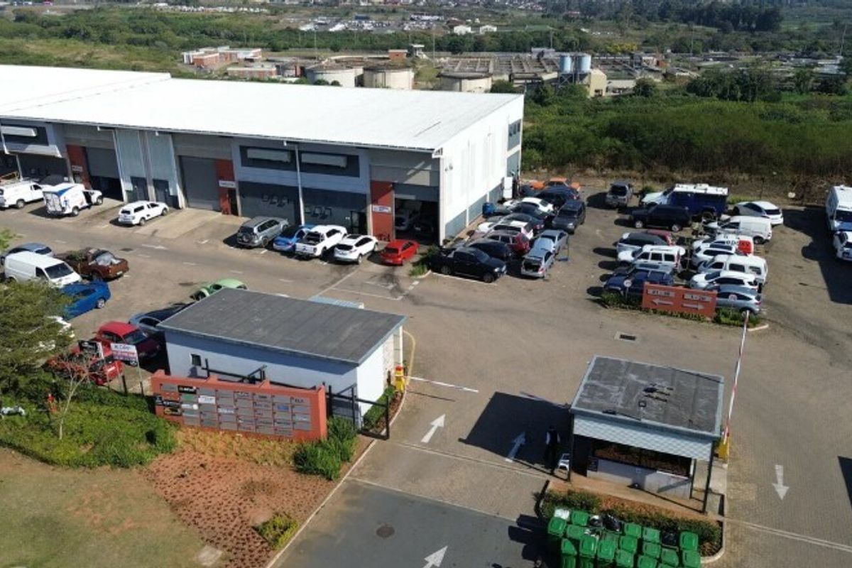 Aerial view of an industrial warehouse complex featuring multiple units, a security gatehouse, and ample paved parking space.