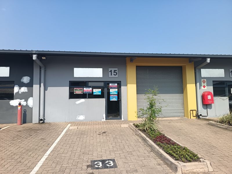 Front elevation of an industrial unit featuring a roller shutter door, dedicated parking bay, and exterior fire safety equipment.