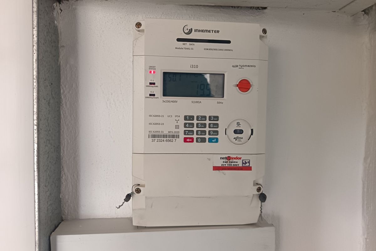 A wall-mounted digital prepaid electricity meter installed in a utility area.