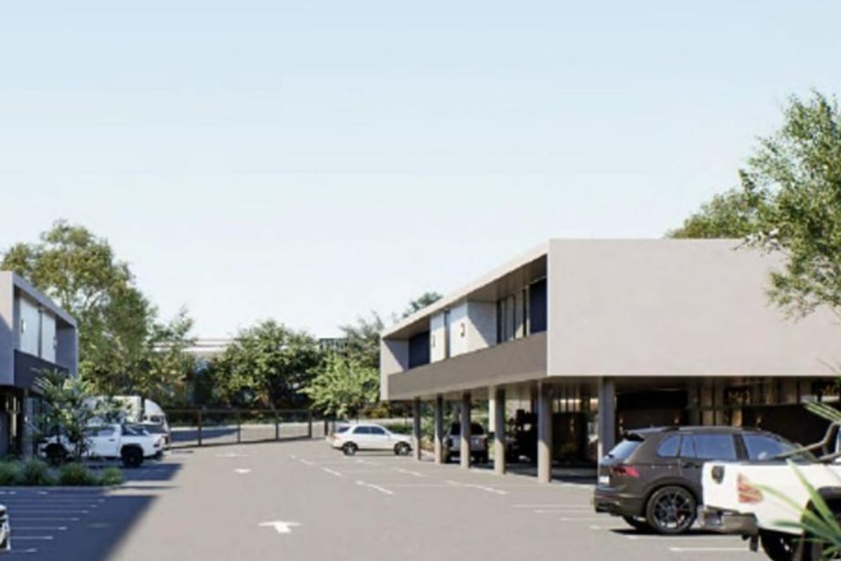 Modern industrial complex featuring a paved parking area with covered bays and contemporary architectural design.