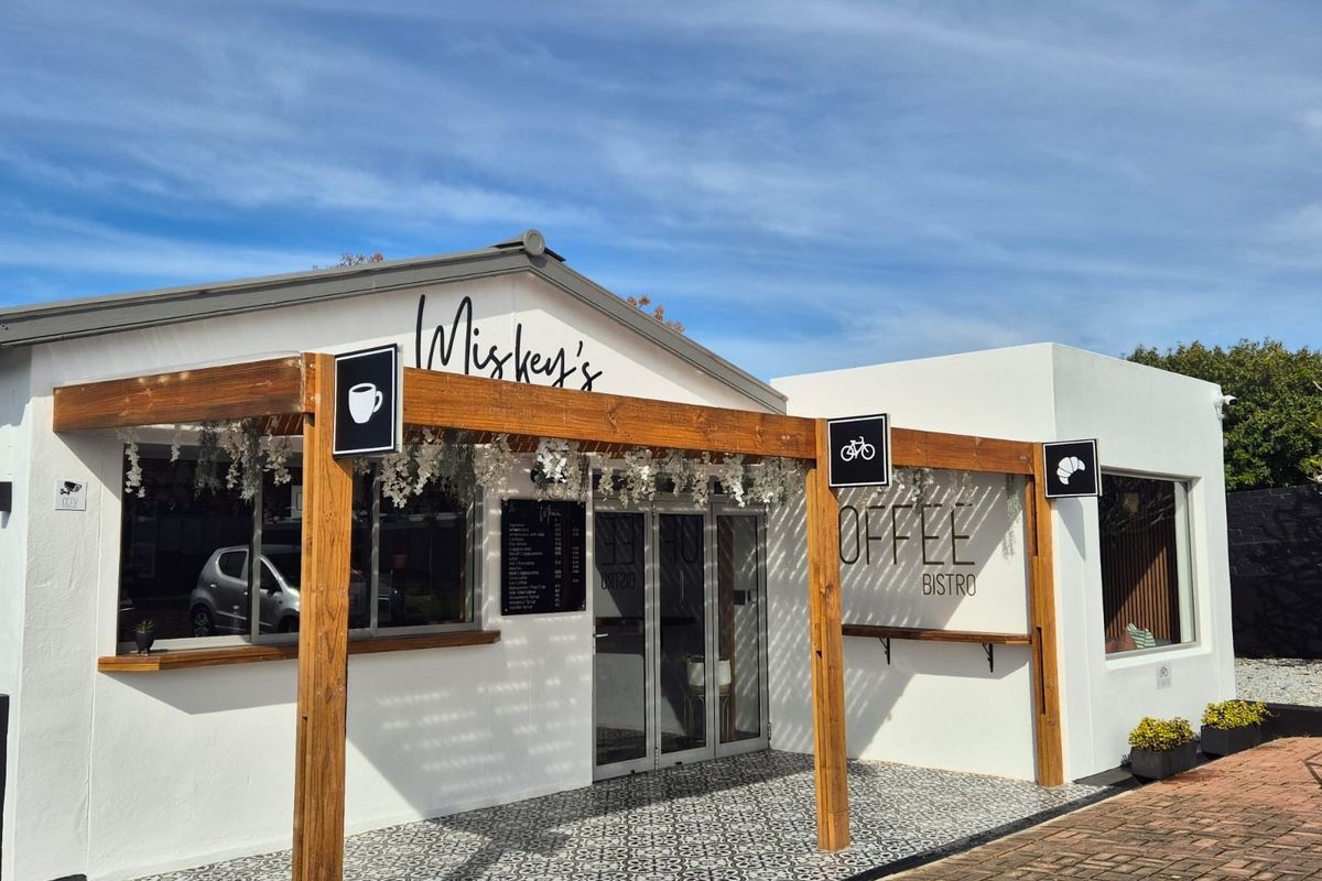 Front facade of a commercial bistro featuring a timber pergola, patterned tiled entrance, and modern glass door entry.