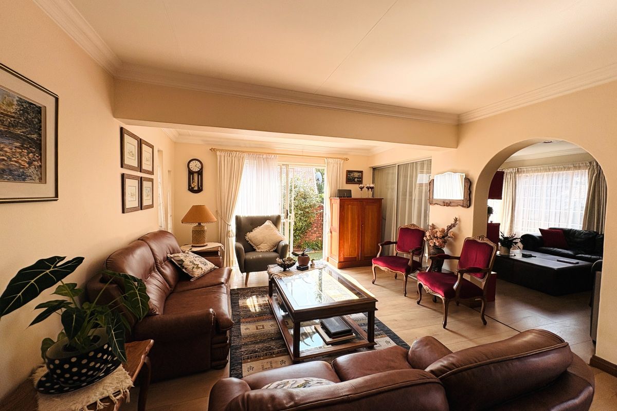 Spacious living room featuring tiled flooring, an arched transition to an adjacent area, and sliding glass doors providing access to the exterior.