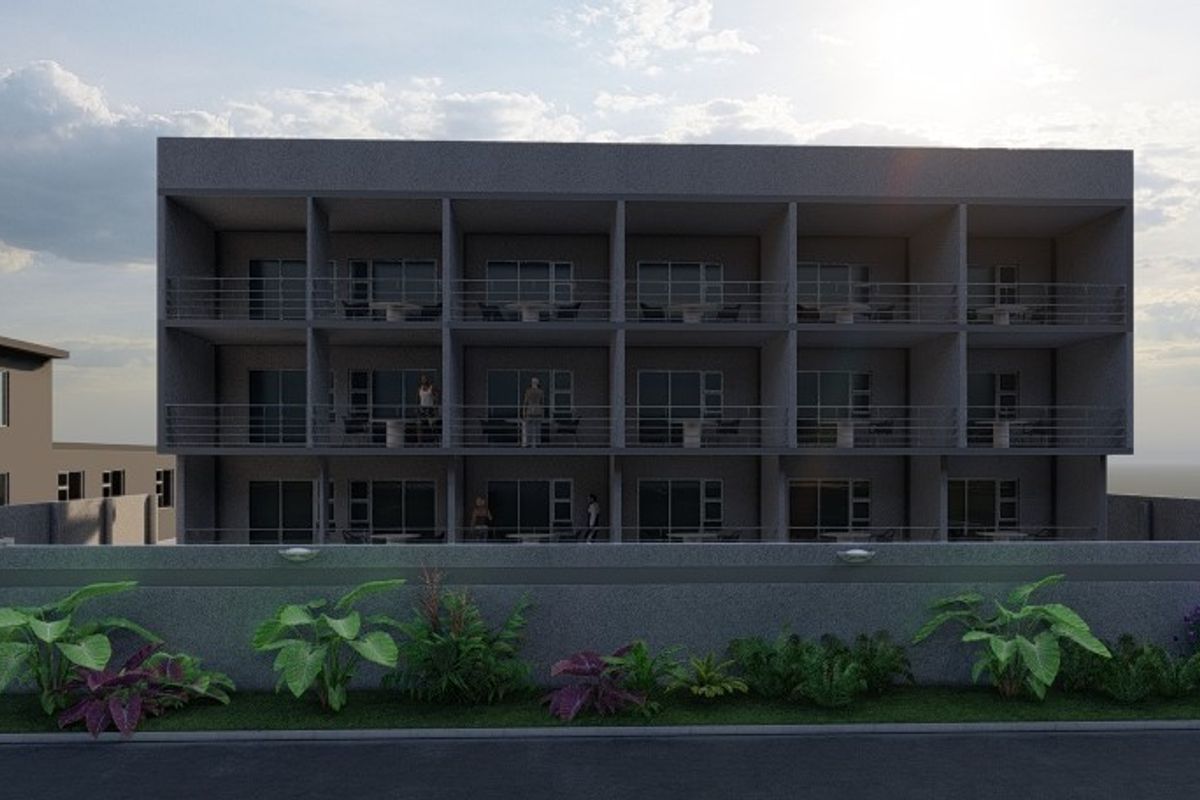 A modern multi-story commercial building facade featuring uniform balconies, sliding glass doors, and a secure perimeter wall with a gated entrance.