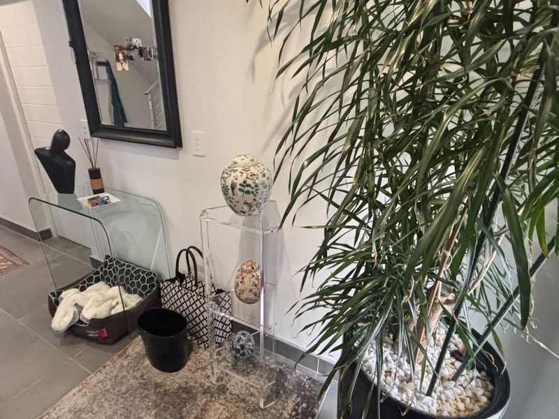 A bright hallway featuring neutral wall finishes and durable tiled flooring, providing a clean and functional transition space within the home.