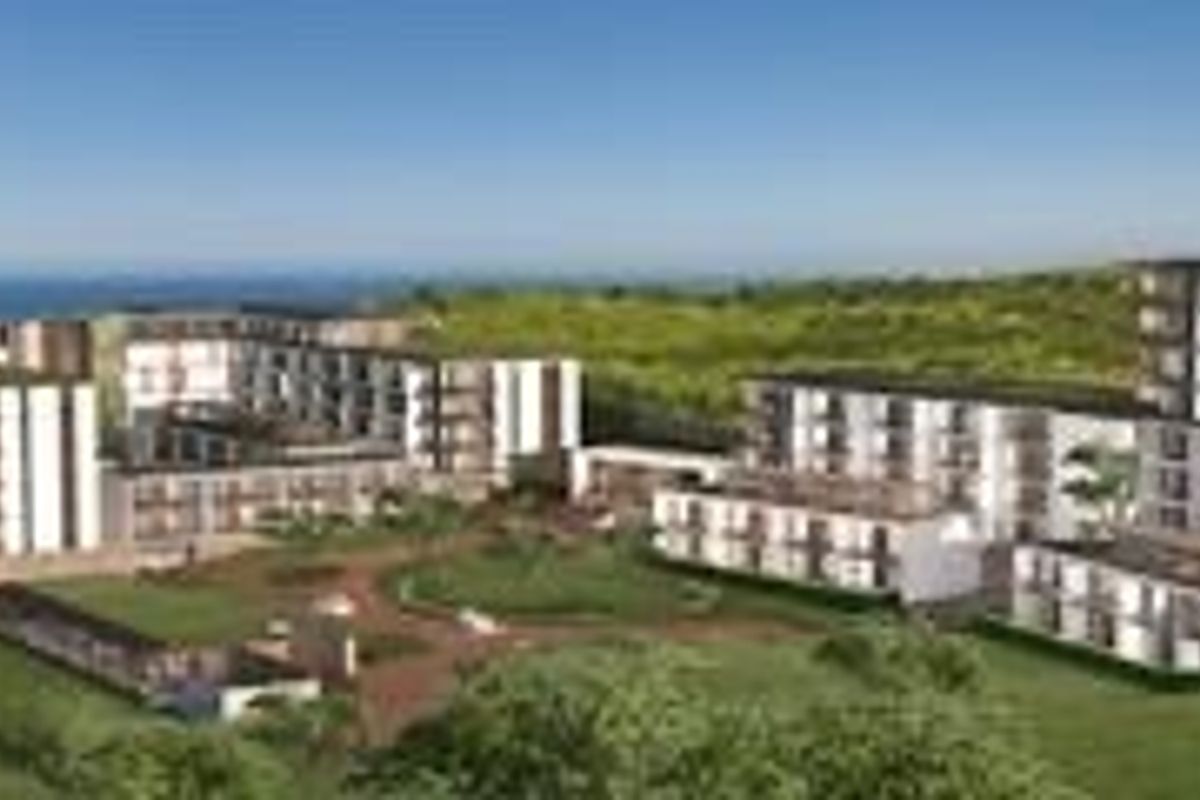 An aerial perspective of a modern multi-story apartment complex situated in a coastal landscape with integrated green spaces and balconies.