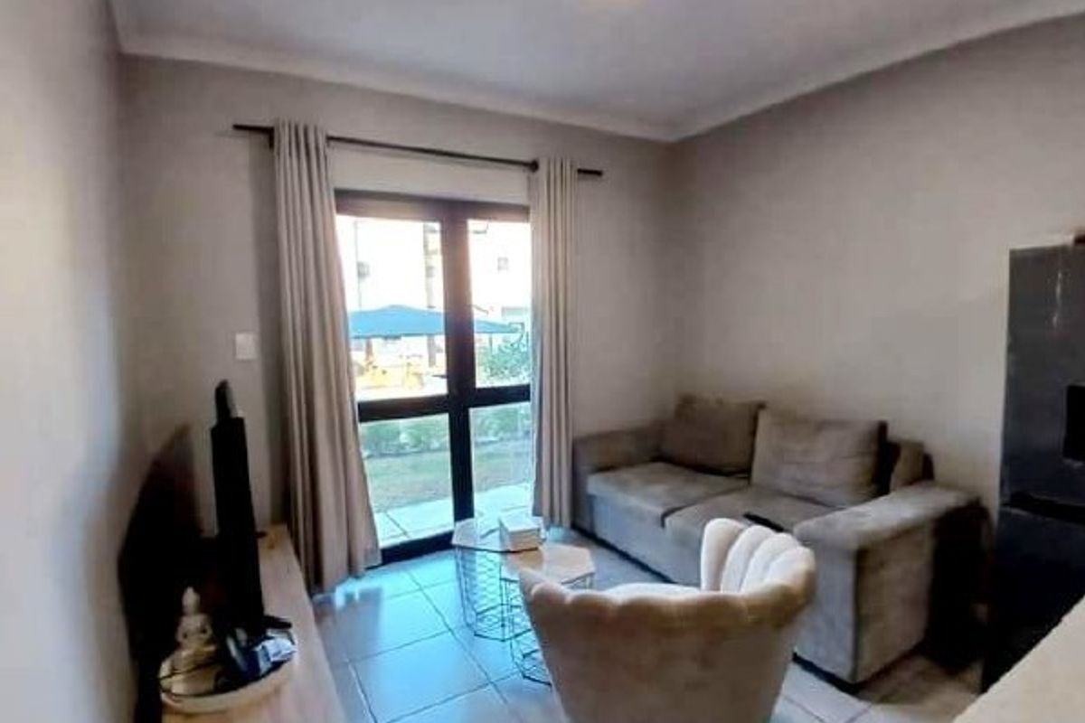 A living room featuring tiled flooring and a sliding glass door providing access to the exterior.