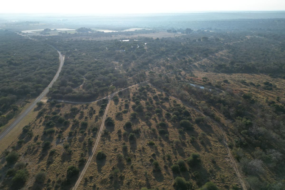 An aerial view of the expansive farm property, showcasing the natural landscape, surrounding vegetation, and access roads.