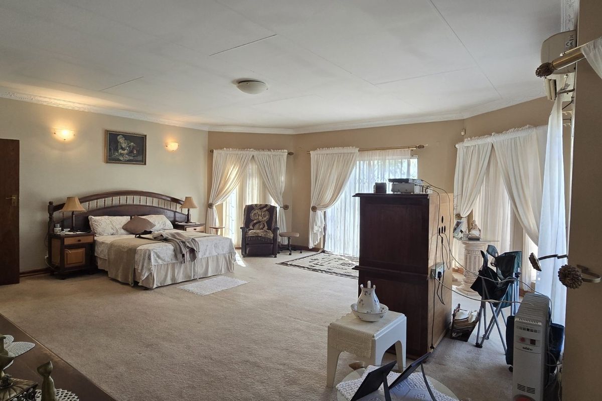 Spacious bedroom featuring crown molding, wall sconces, and large sliding glass doors providing natural light and access to the exterior.