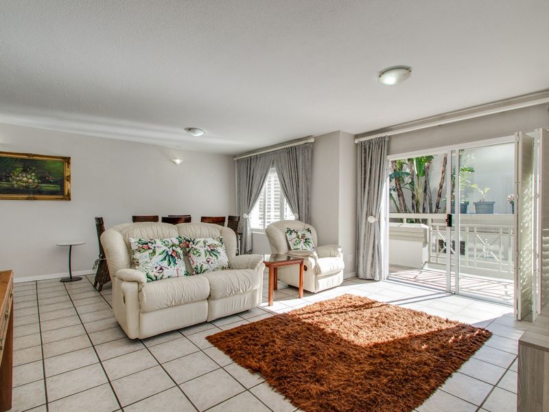 Open plan living area featuring tiled flooring and large sliding glass doors providing access to an outdoor patio space.