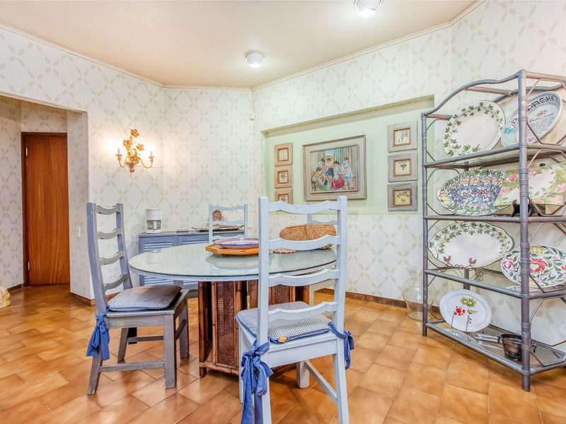 A dining room featuring ceramic tile flooring, a recessed wall niche, and decorative wall sconce lighting.