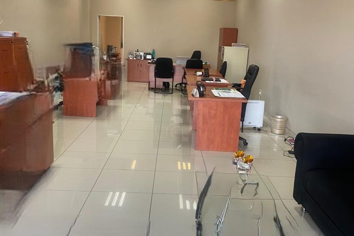 Open-plan office space featuring tiled flooring and recessed ceiling lighting, providing a functional workspace environment.