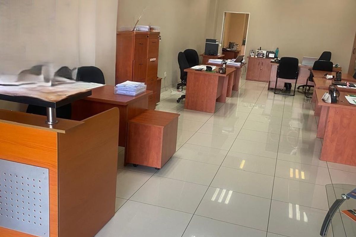 Open-plan office space featuring polished ceramic floor tiles and a suspended ceiling with integrated recessed lighting.