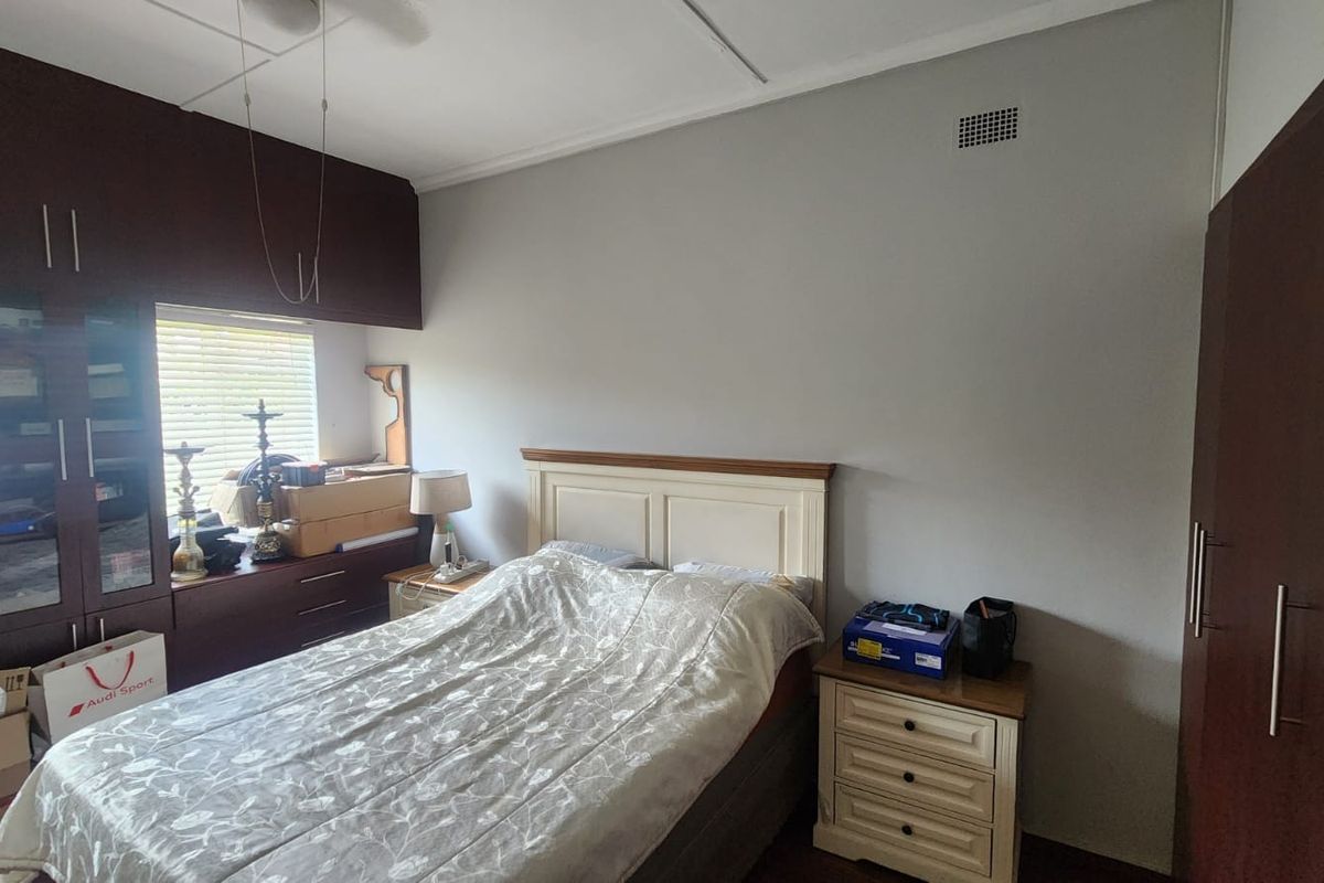 A bedroom featuring built-in dark wood cabinetry and a ceiling vent, providing functional storage space.