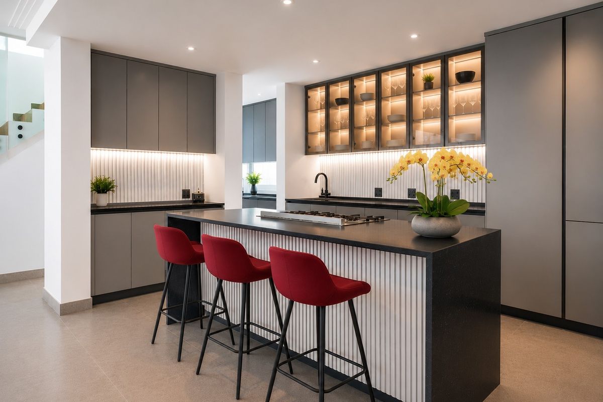 Modern, high-end kitchen featuring a central island with a gas cooktop, sleek grey cabinetry, integrated display lighting, and premium stone countertops.