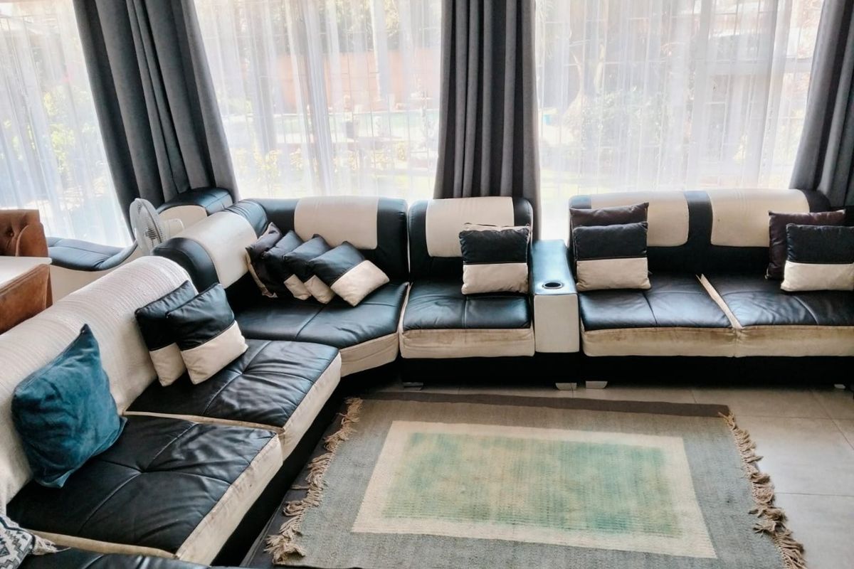 A living room area featuring tiled flooring and large windows that allow for natural light.